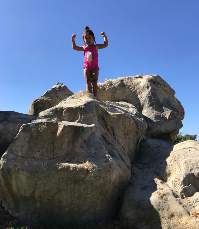 Child climbing a rock at Emerald Glen