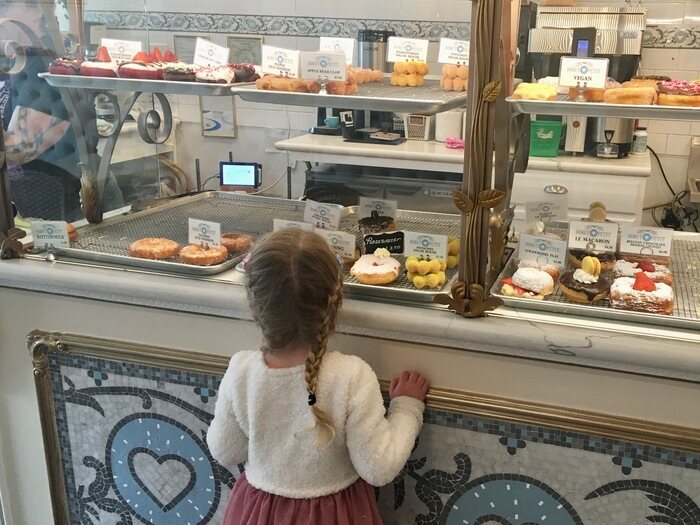 Child looks at selection of donuts