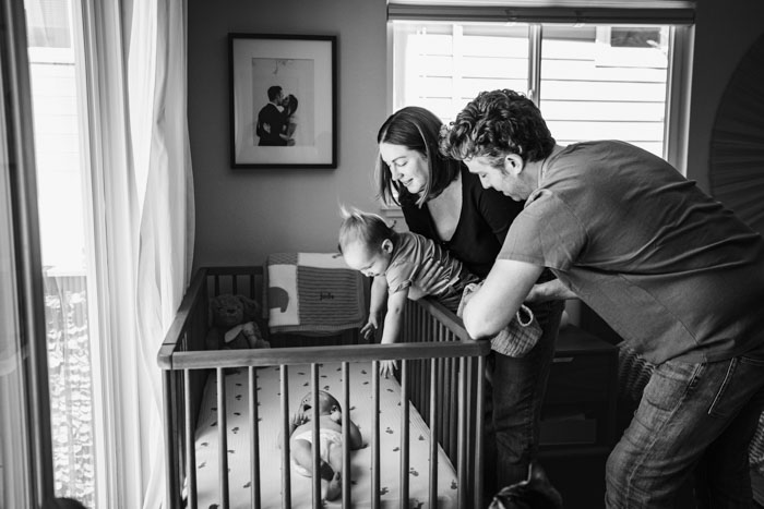 black and white family photo, two parents, one toddler, one baby