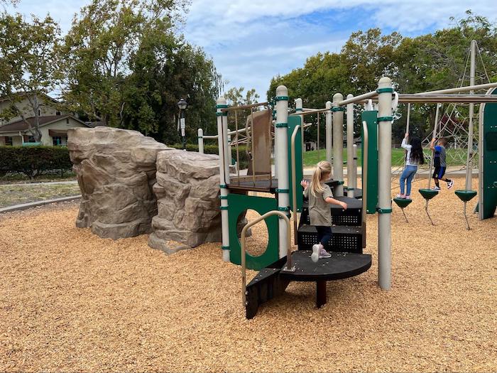 play structure with little girl climbing the stairs