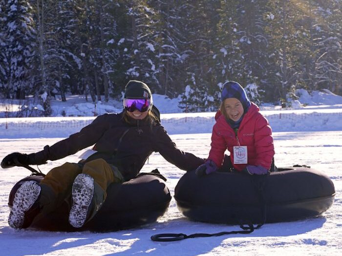 Mother and son on snow tubes at tubetahoe