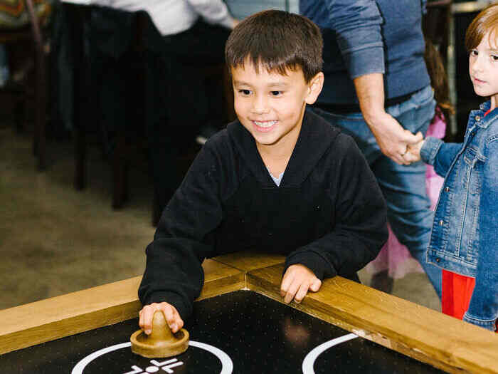 Kid playing air hockey