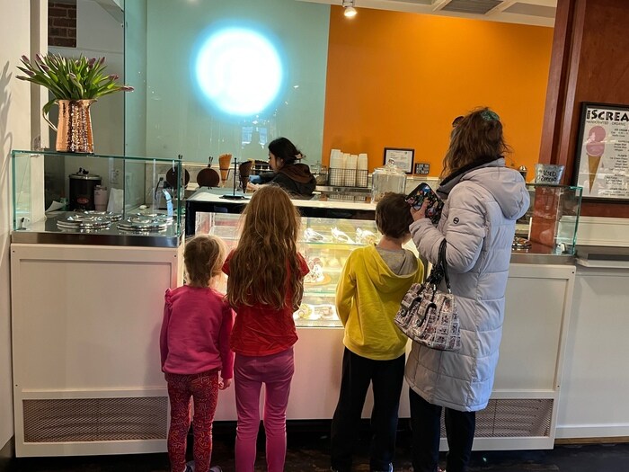 Kids and adult standing at ice cream store