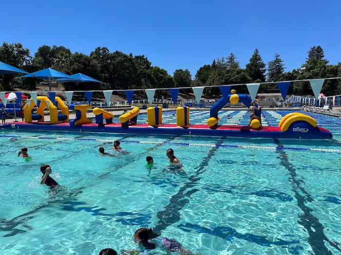 smaller person obstacle course at a public swimming pool on the water